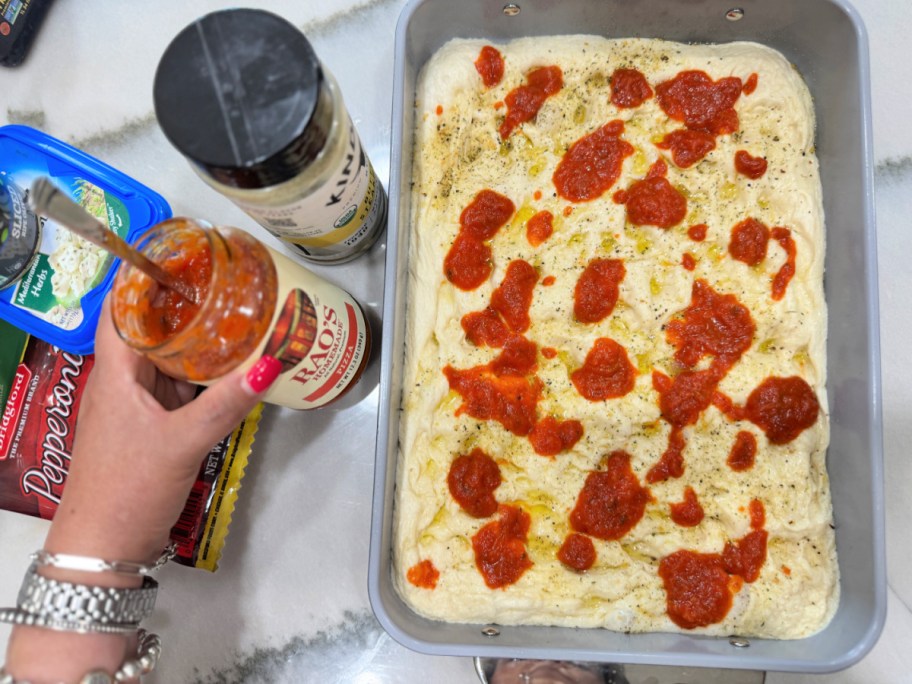 adding rao's pizza sauce to focaccia bread